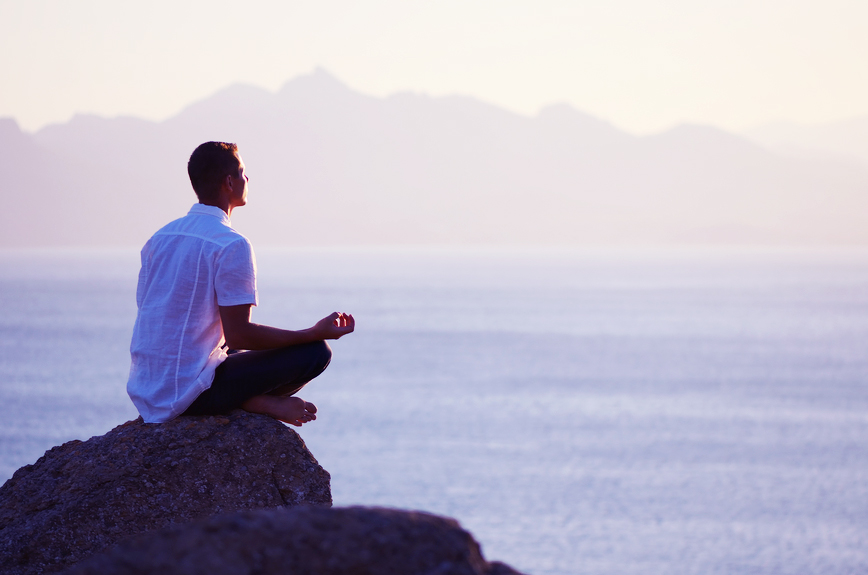 Guy sitting on a rock in the lotus position